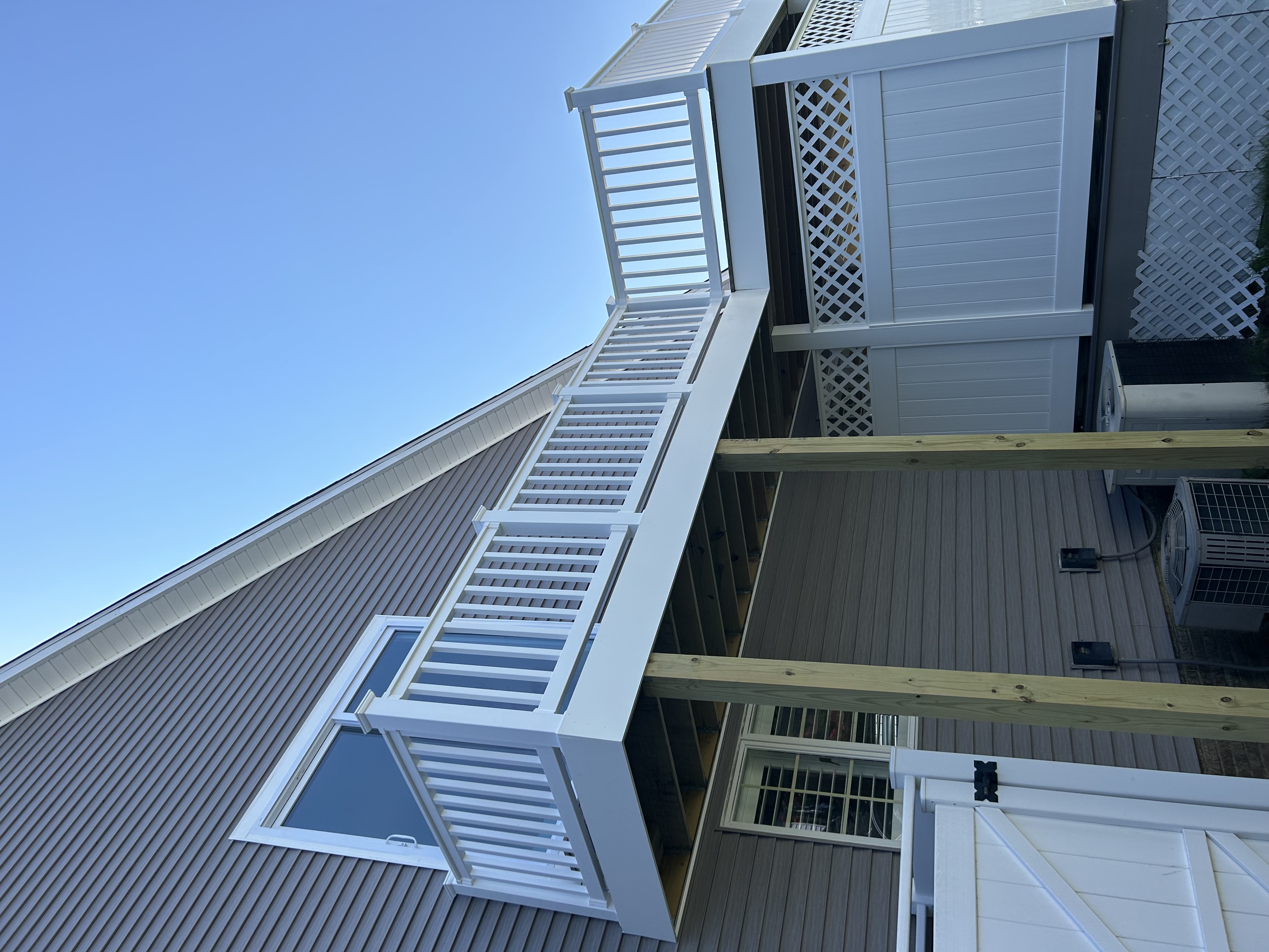 Coastal home deck addition with upper balcony