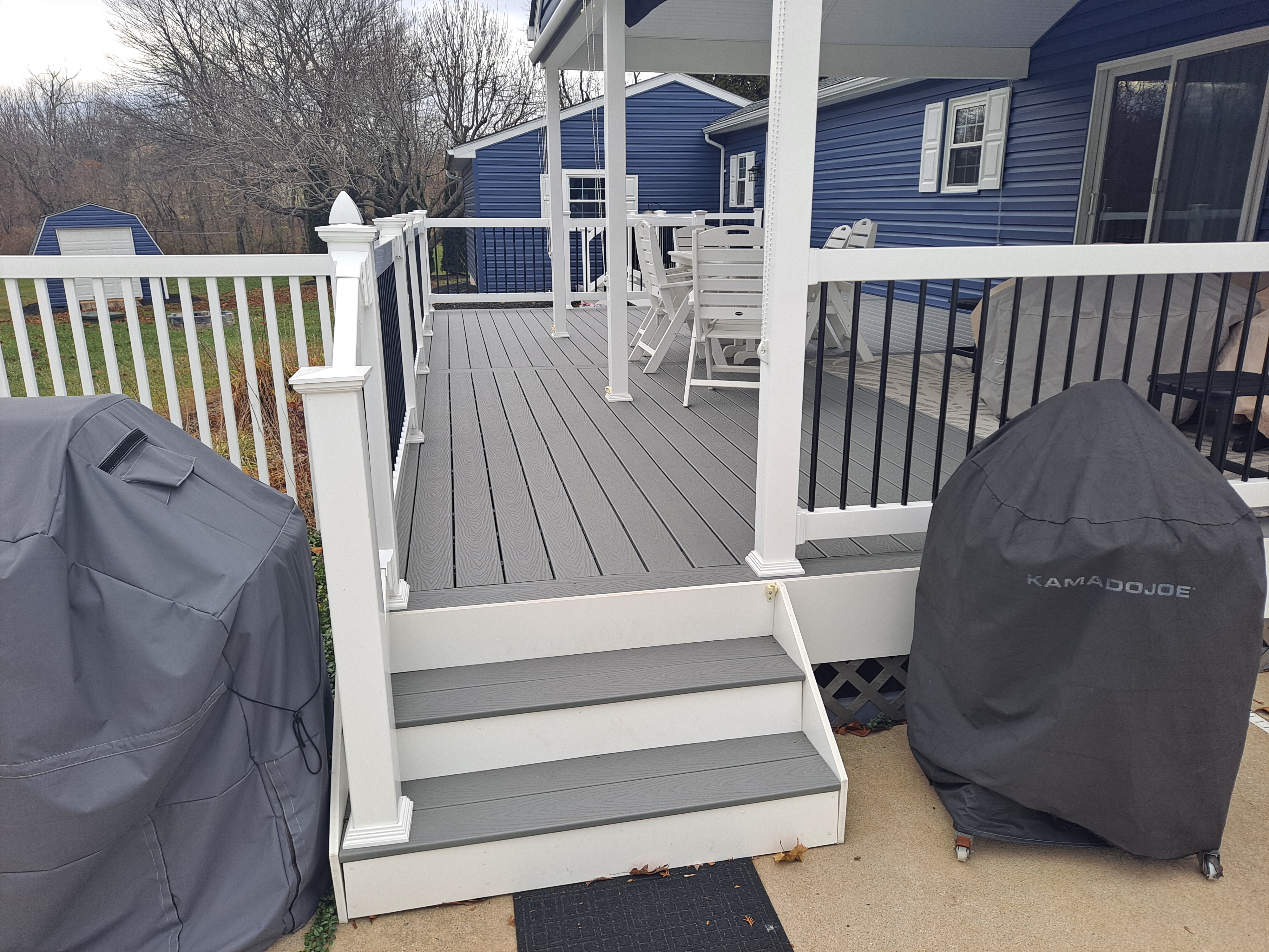 Covered deck addition on a navy blue sided home