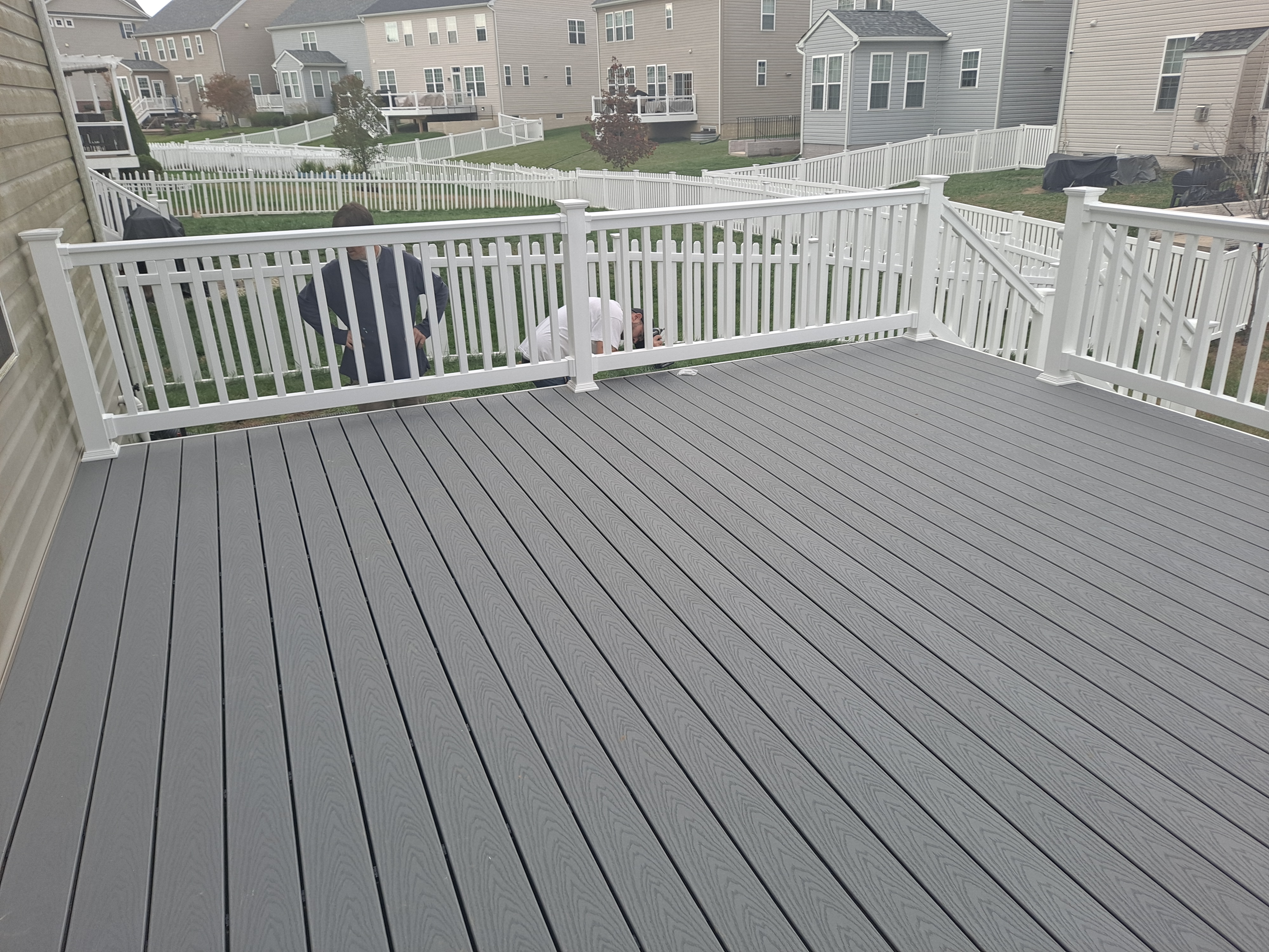 Gray composite deck build with white vinyl railing