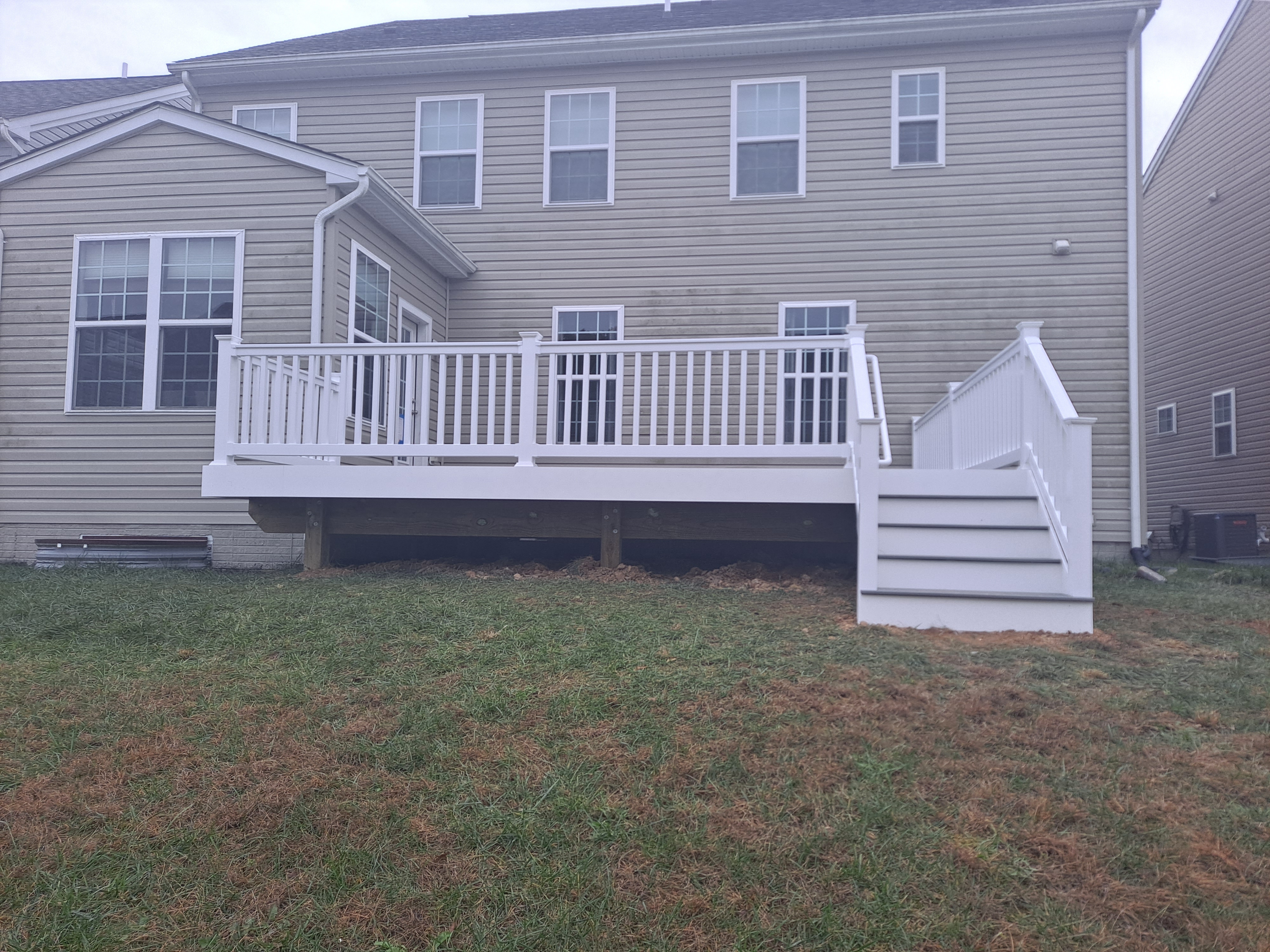 Completed gray composite deck with white vinyl railing
