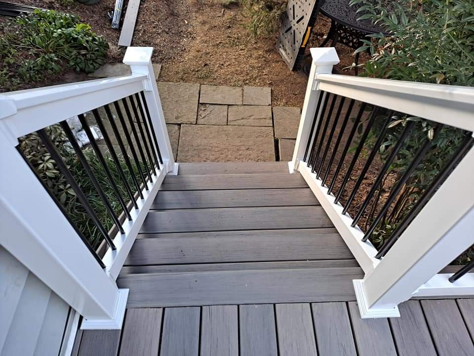 Deck stair and railing detail looking down to a stone patio