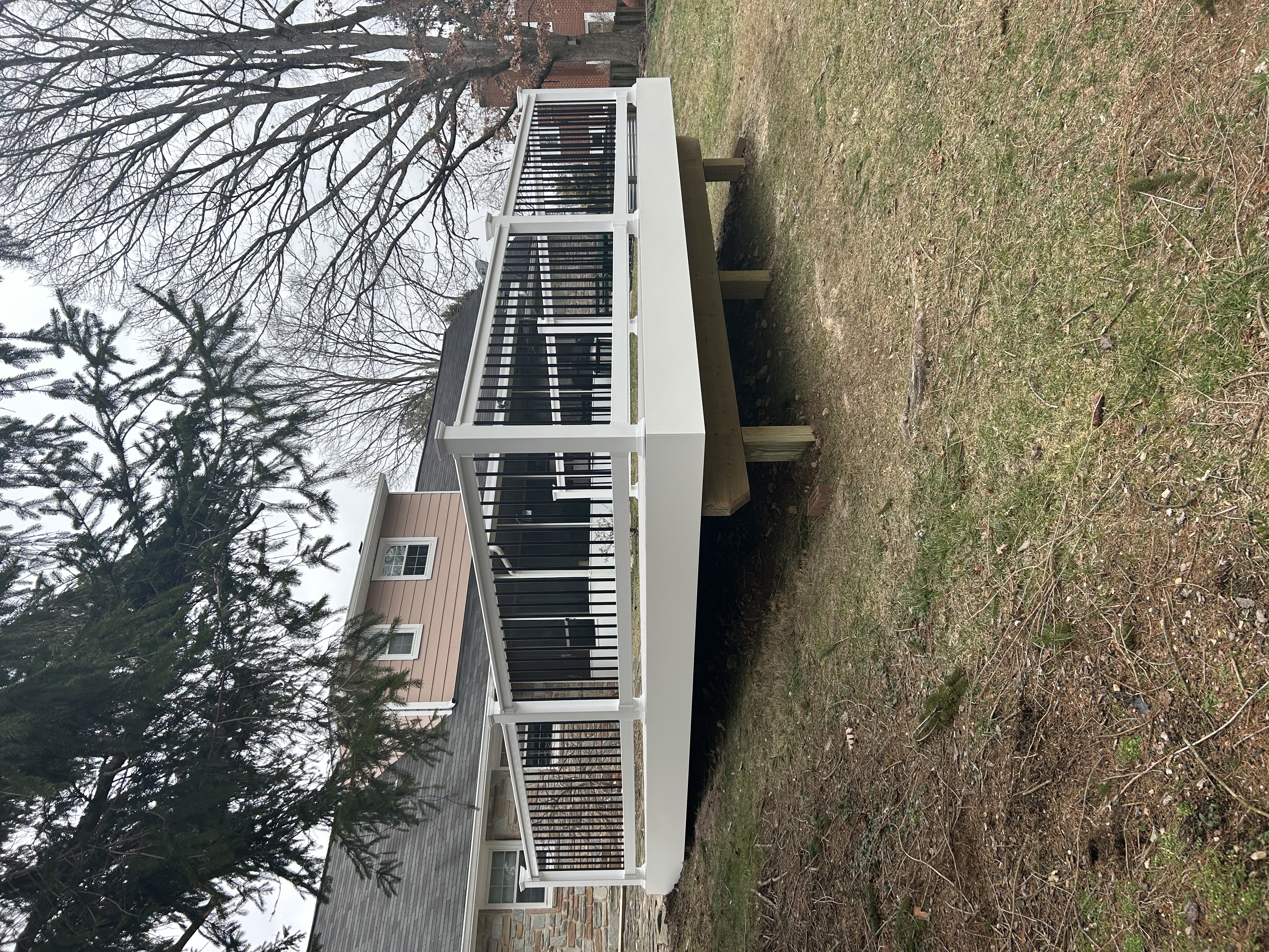 Composite deck with white and black railing, ground-level view