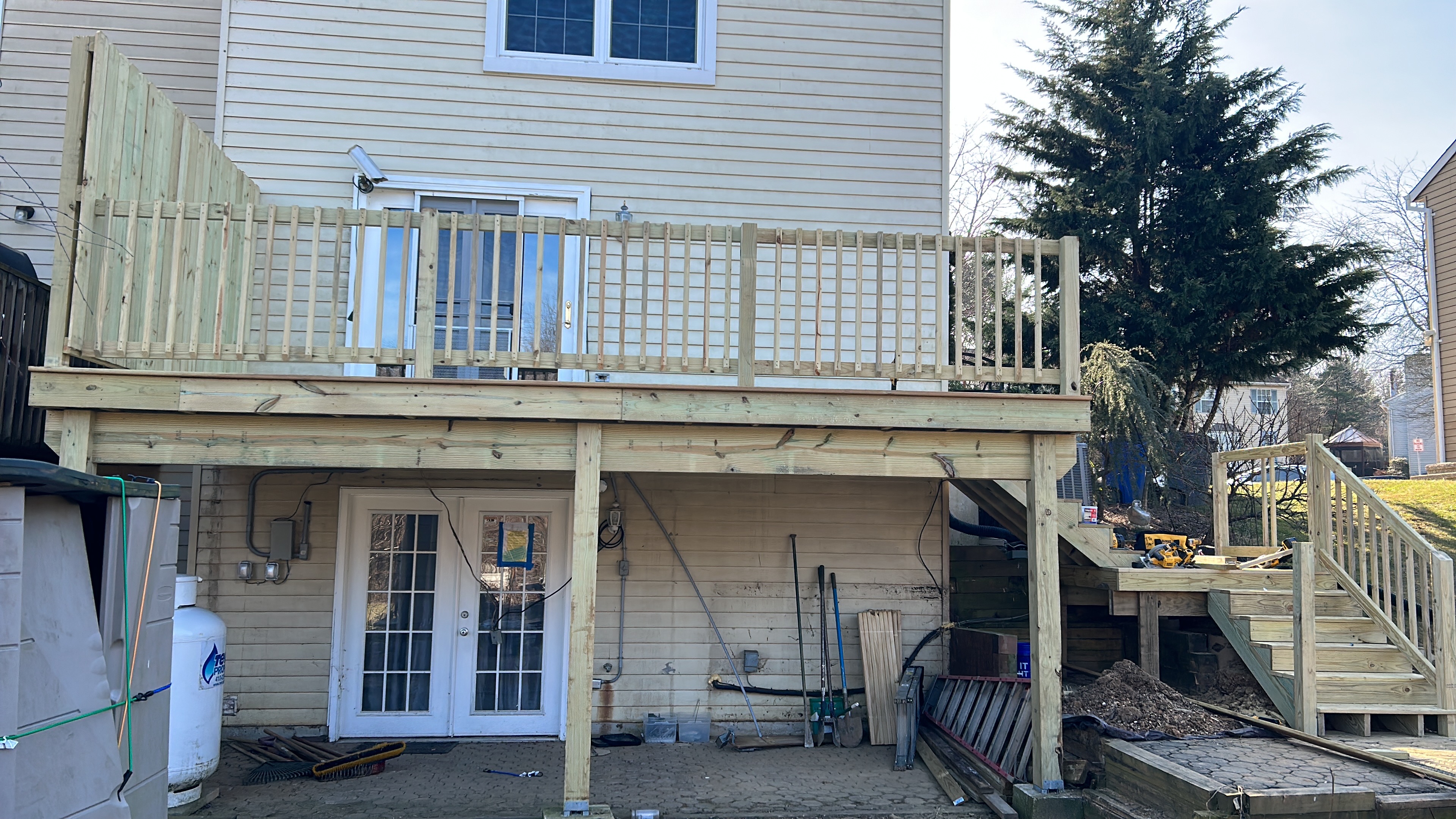 Elevated deck under construction with framing and tools visible