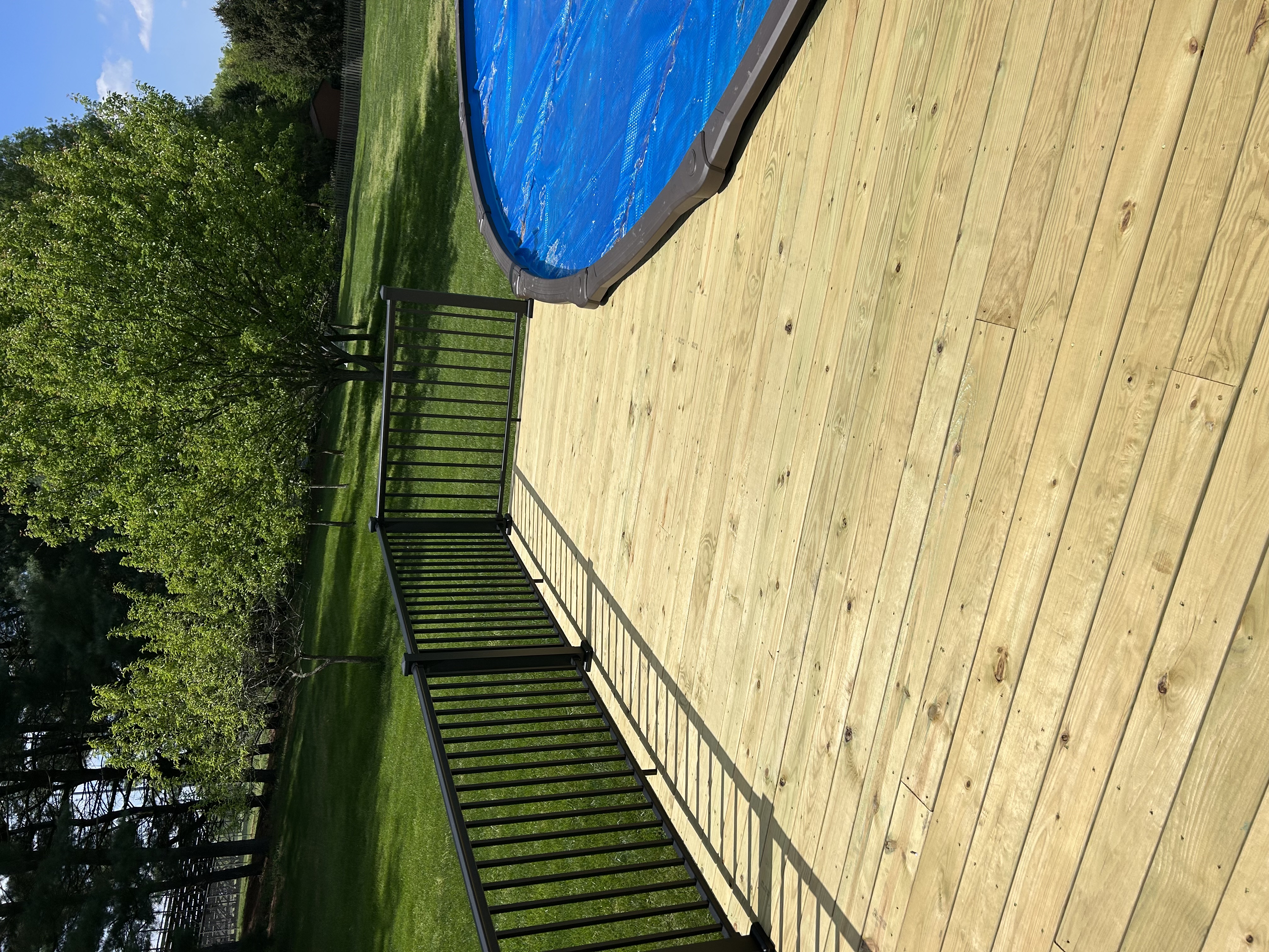 Pool deck with black aluminum railing, ground-level view