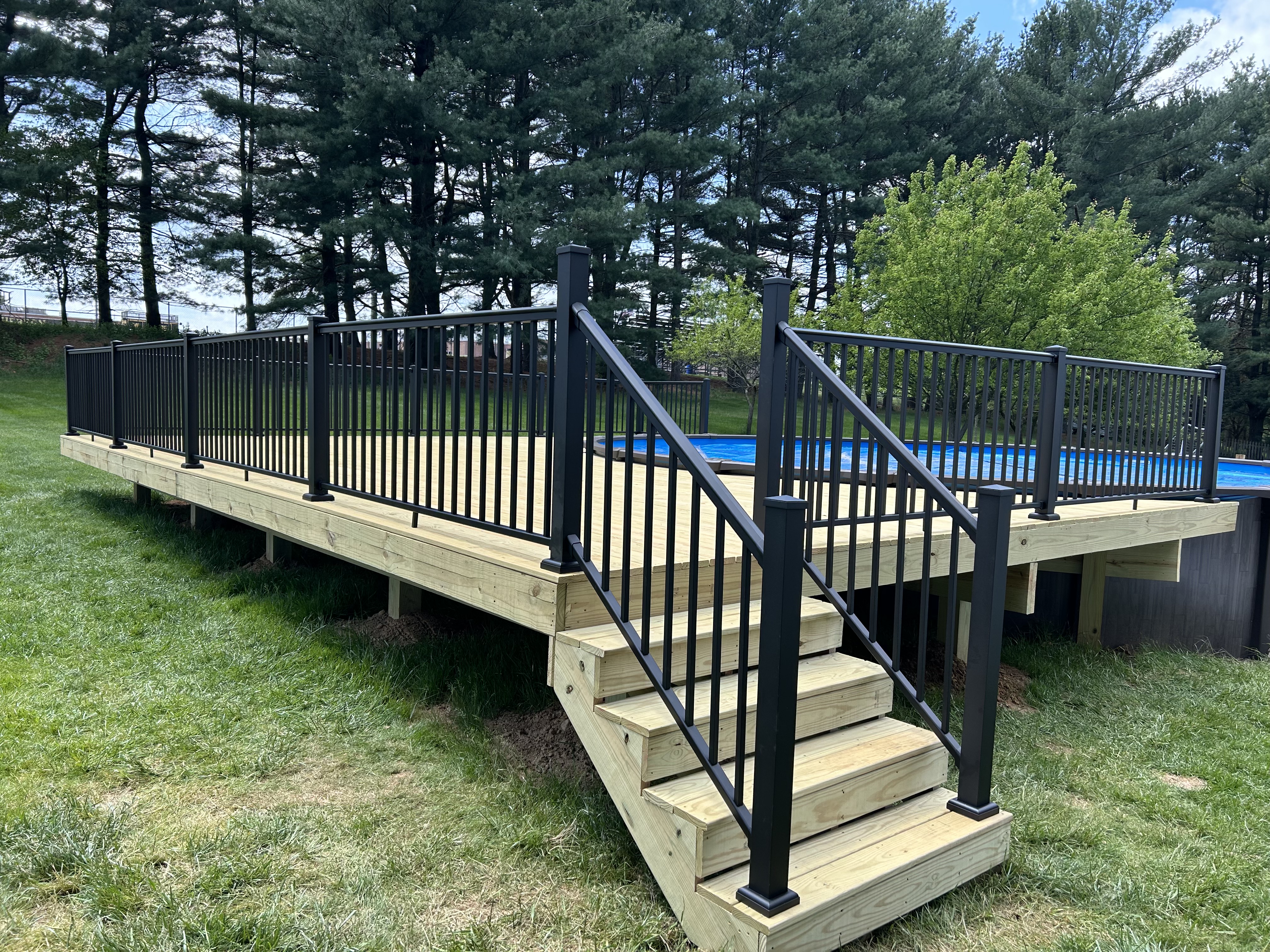 Pool deck with black aluminum railing and staircase