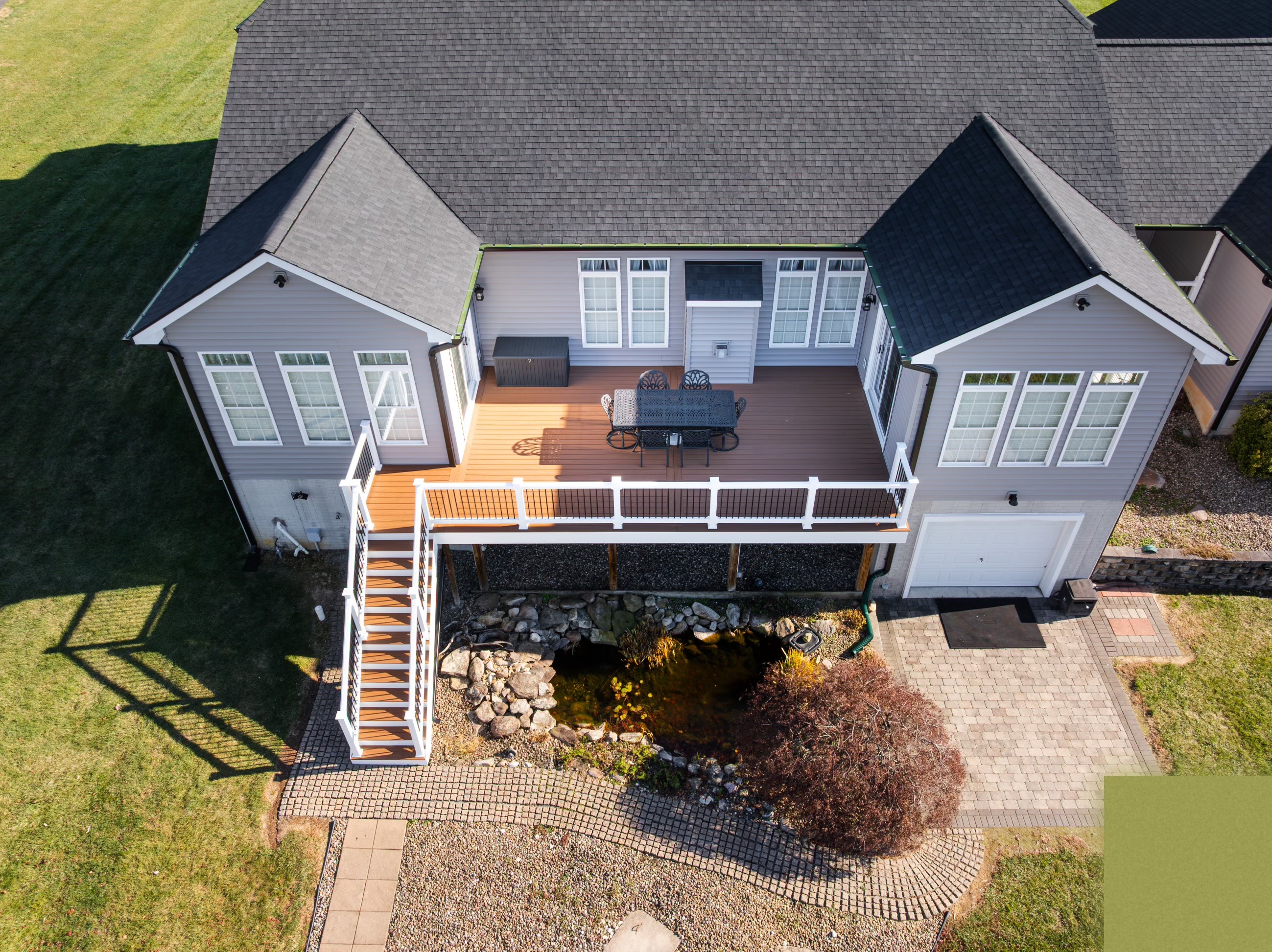 Aerial view of a roof replacement with deck and koi pond below