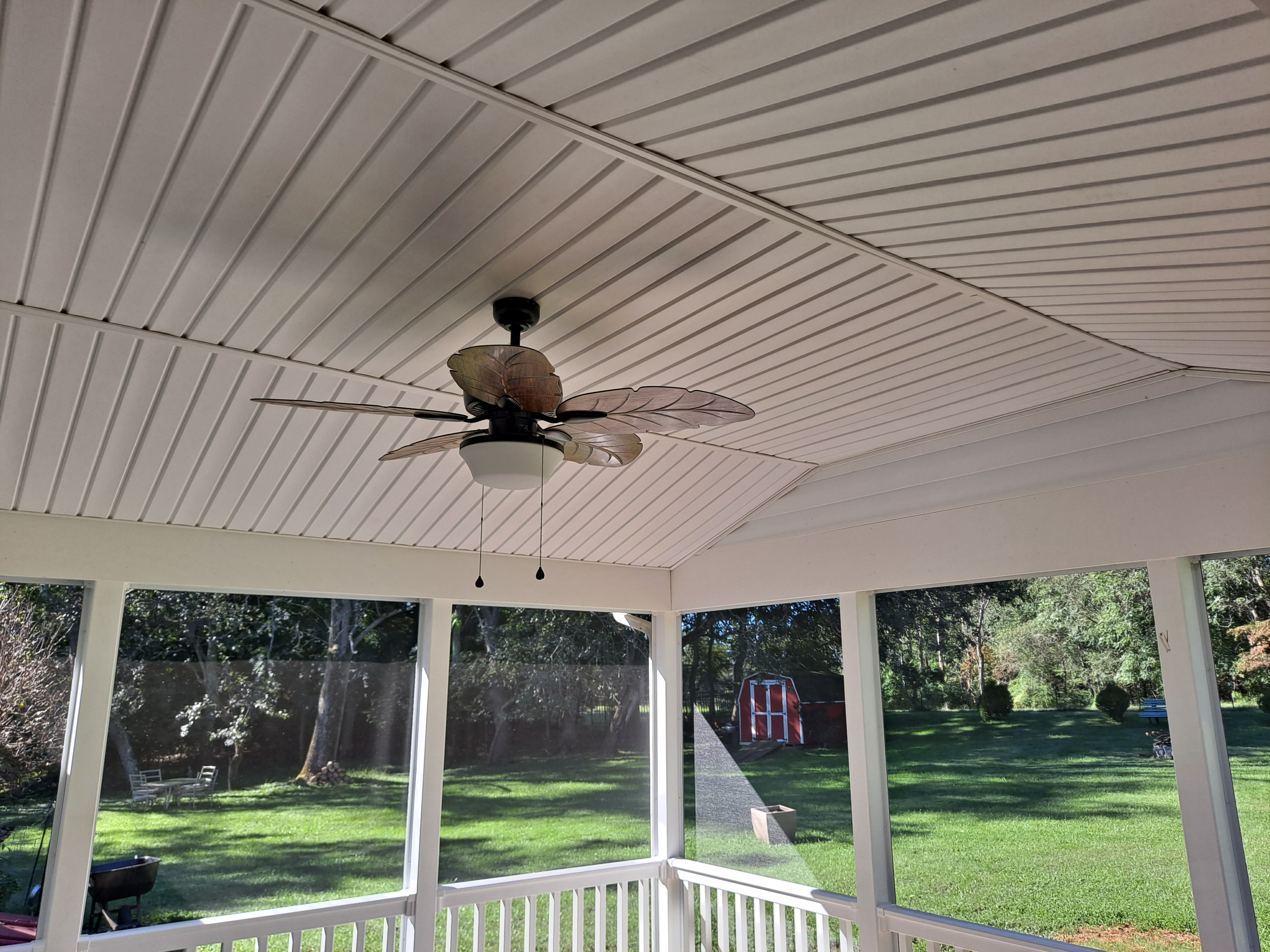 Screened porch interior with vaulted beadboard ceiling and fan