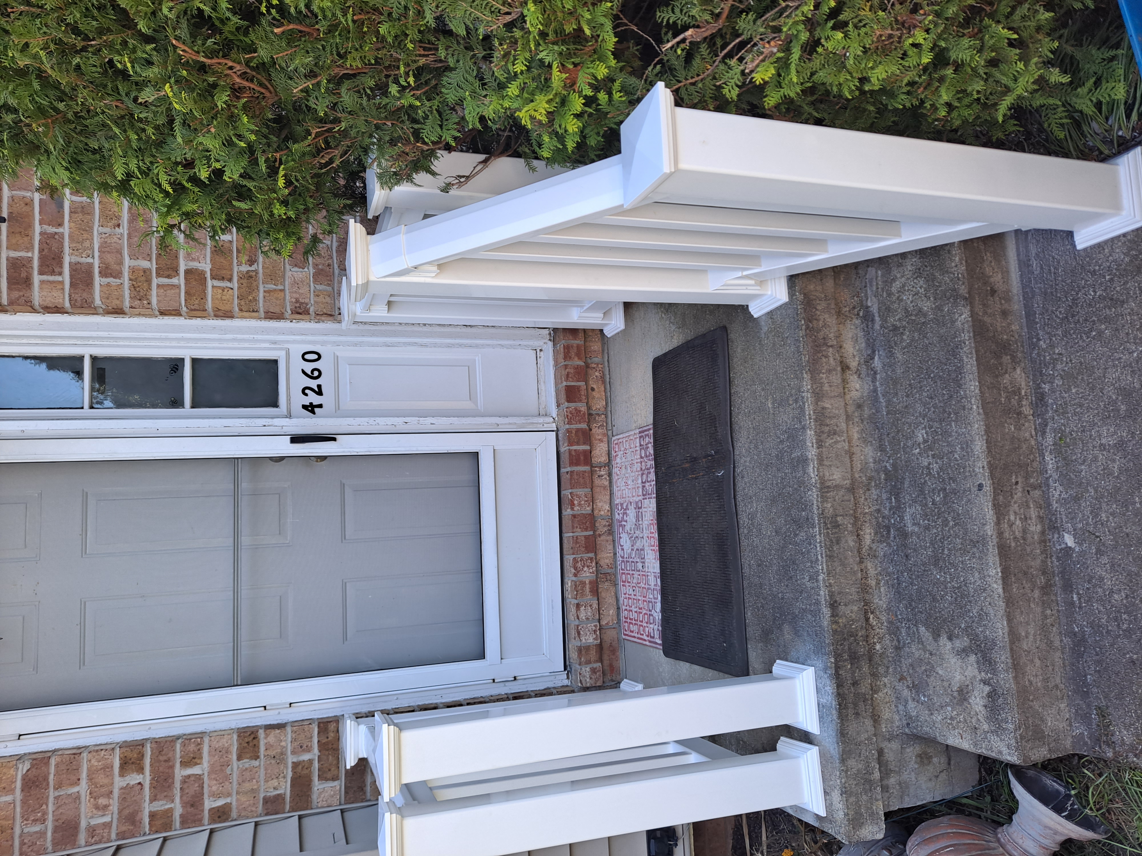 Front entry steps with new white vinyl railing replacing the old one