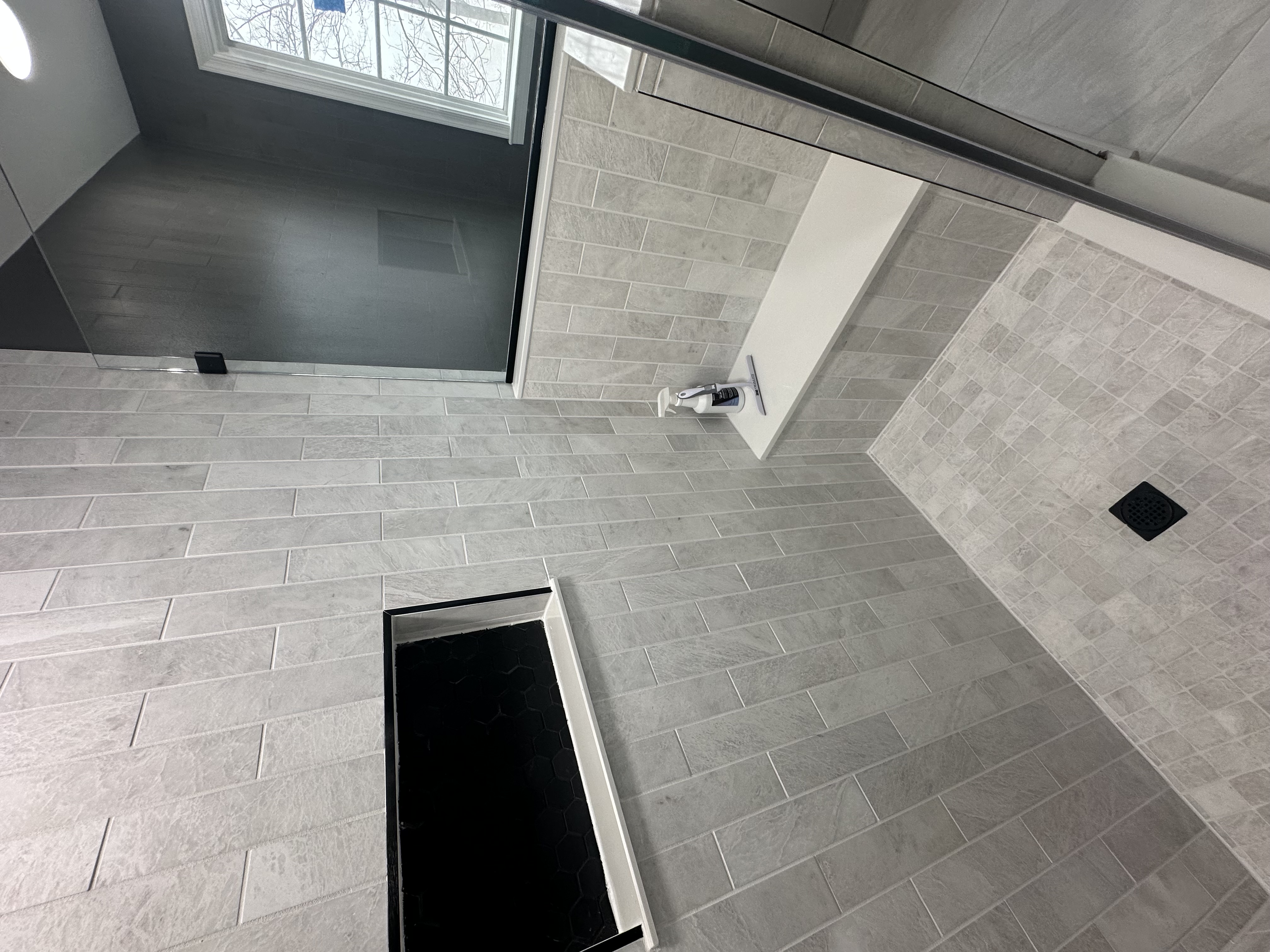 Luxury bathroom shower with built-in bench and black tile niche