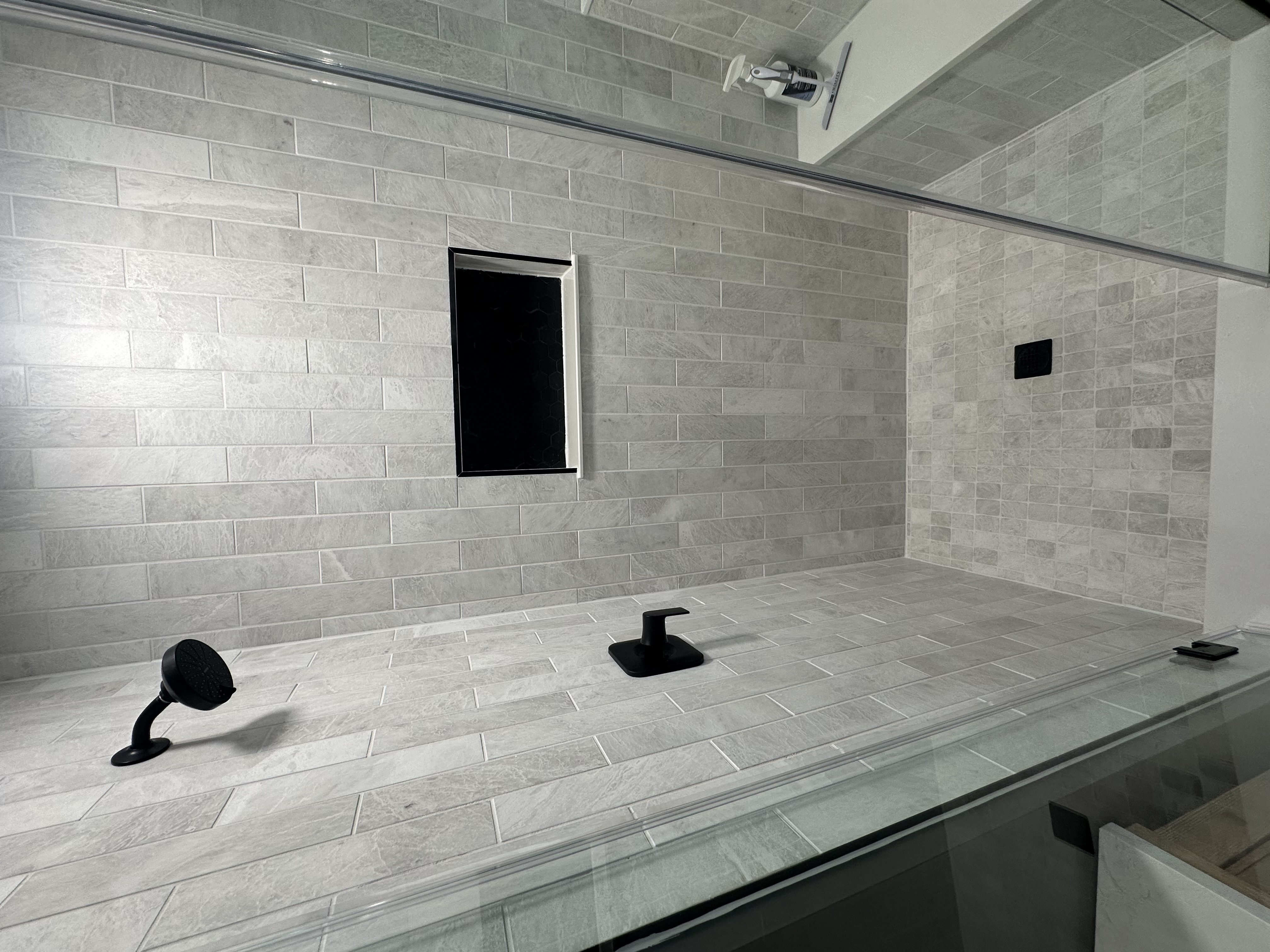 Luxury bathroom shower with matte black fixtures and tile niche