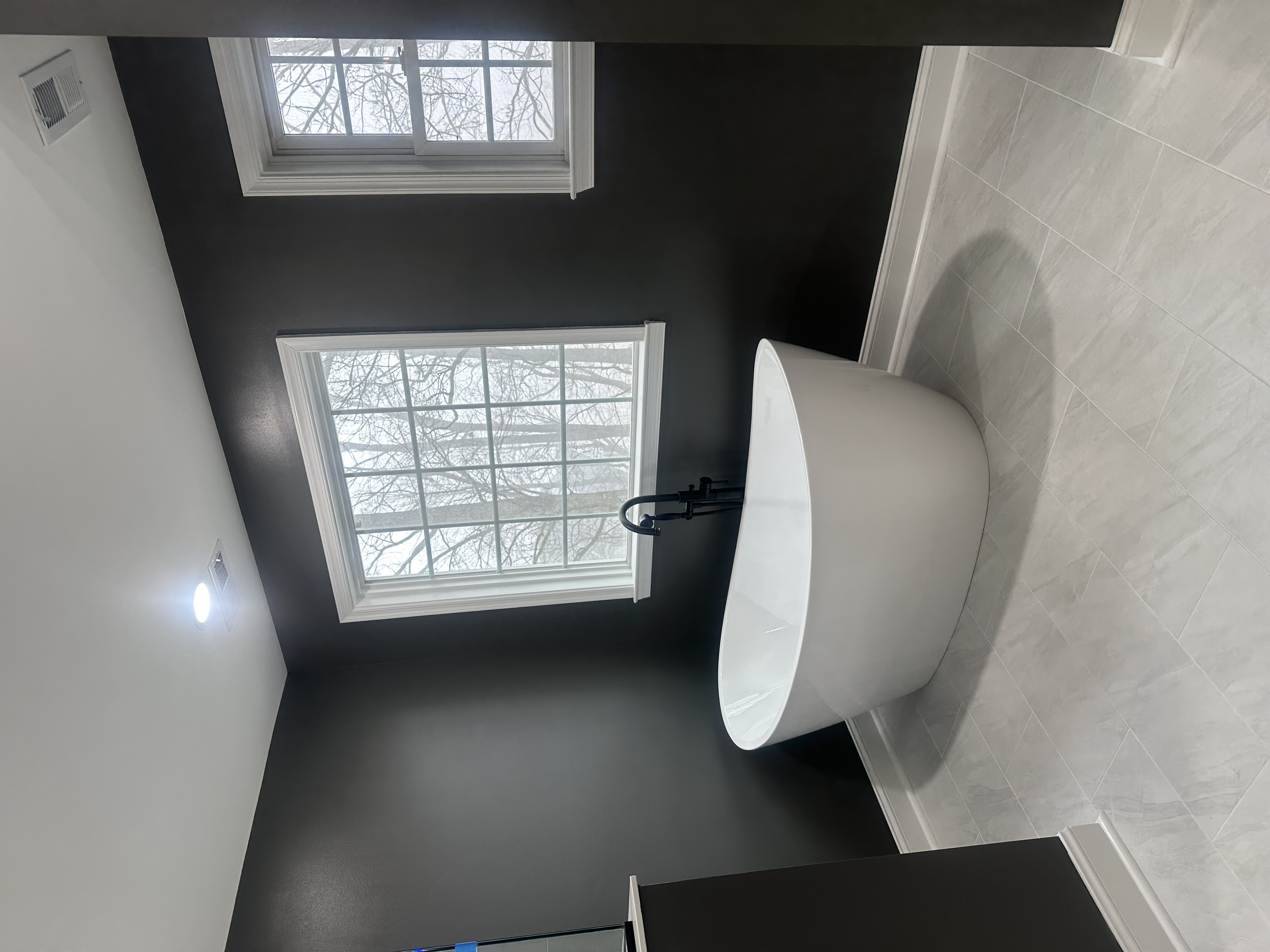 Luxury bathroom remodel with freestanding soaking tub and matte black fixtures