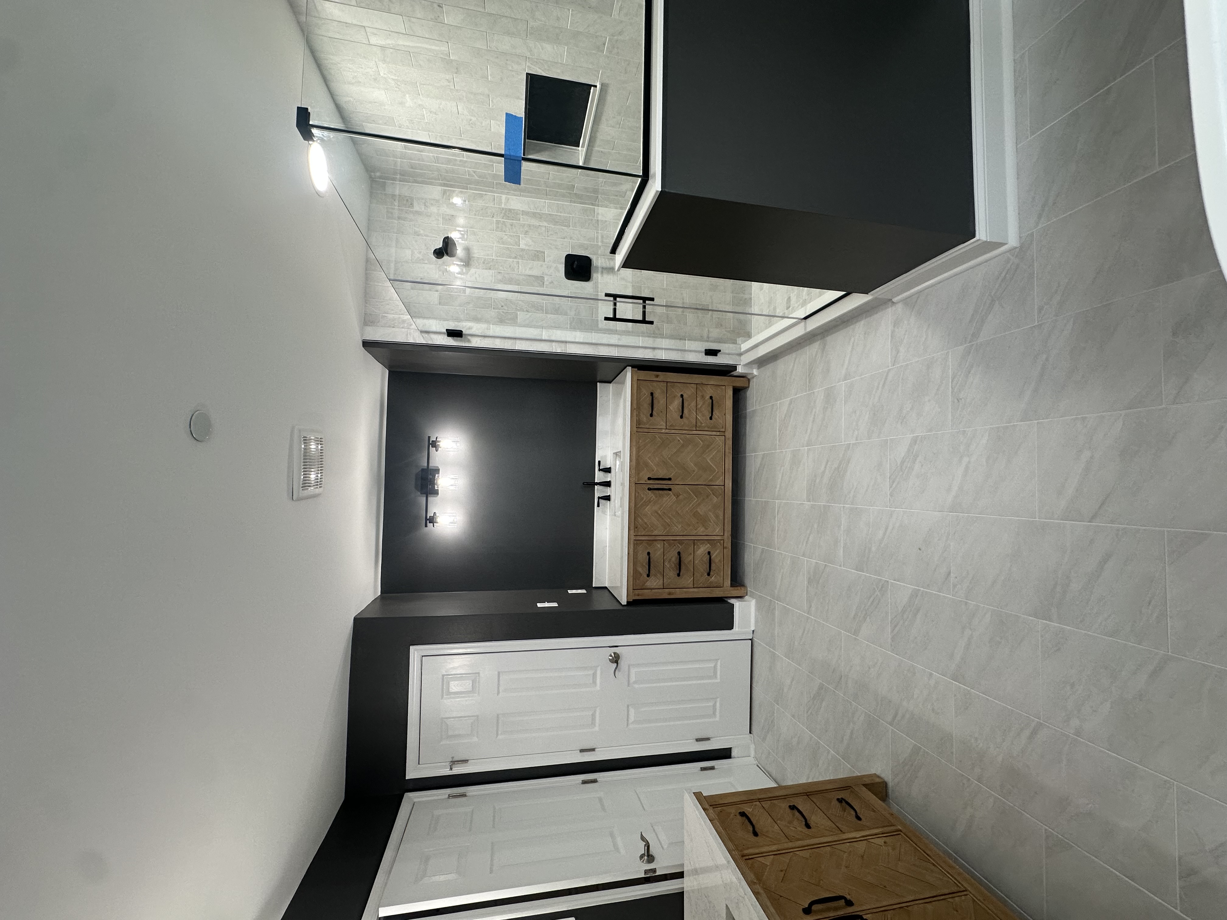 Luxury bathroom remodel with wood vanity and glass-enclosed shower