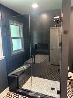 Bathroom remodel with dark slate tile shower bench and niche